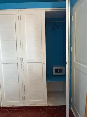 a closet with white doors in a room at PLAYA BLANCA BED AND BREAKFAST in Bayahibe