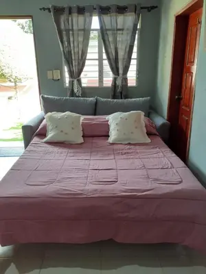 a bedroom with a large bed with a purple bedspread at CASITA HOGAREÑA JARABACOA (independent entrance) in Jarabacoa