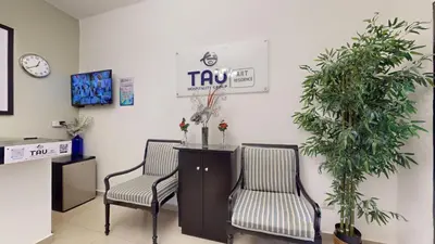 a waiting room with two chairs and a clock at Hotel Tau Art Residence in Santo Domingo