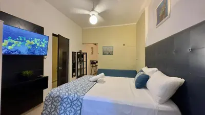 a bedroom with a large bed with blue and white pillows at Hotel Tau Art Residence in Santo Domingo