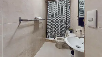a bathroom with a toilet and a sink and a shower at Hotel Tau Art Residence in Santo Domingo