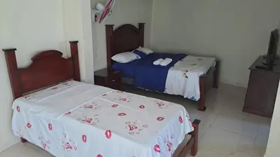 a bedroom with two beds and a tv in it at Casa taina in Jarabacoa