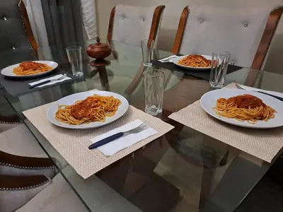 a glass table with three plates of pasta on it at Casa taina in Jarabacoa