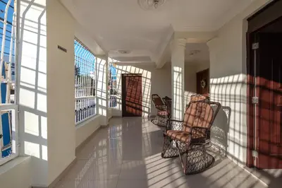 a hallway with chairs and windows in a building at Cozy One Bedroom Apartment in Santo Domingo Este in La Viva