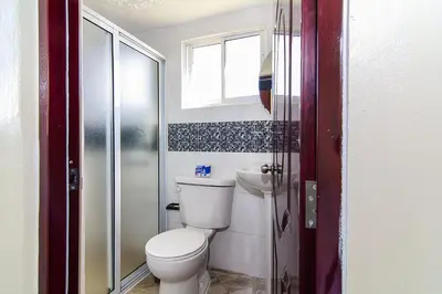 a bathroom with a toilet and a sink and a window at Modern Studio Near Airport Fast WiFi Generator in La Viva