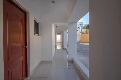 an empty hallway with a red door in a white building at Modern Studio Near Airport Fast WiFi Generator in La Viva