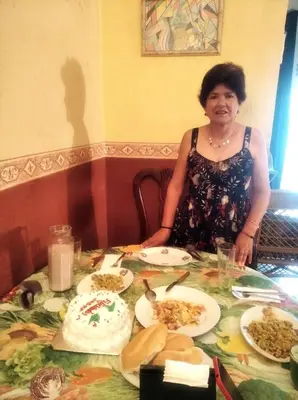 a woman sitting at a table with plates of food at La casa de Jessica in Santo Domingo