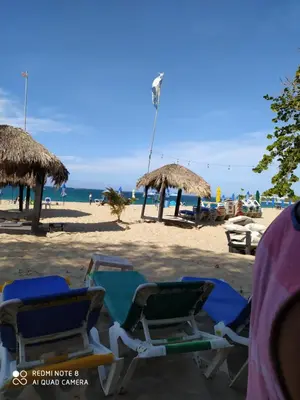 a group of chairs and umbrellas on a beach at Cozy Studios-Private Entrance- HS Internet-AC-Hot Water-Backup Generator-near the Beach in San Felipe de Puerto Plata
