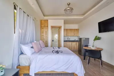 a bedroom with a bed and a table and a kitchen at Villa Favella-Pop-Art-View-7BR-Jamaca De Dios-Balcony-Dream in Jarabacoa