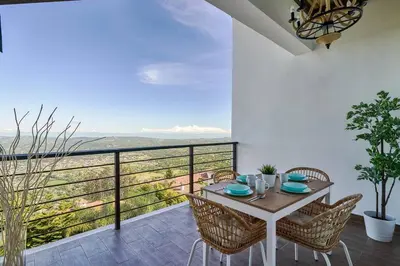a dining room with a table and chairs and a balcony at Villa Favella-Pop-Art-View-7BR-Jamaca De Dios-Balcony-Dream in Jarabacoa