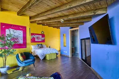 a bedroom with a bed and a tv in a room at Villa Favella-Pop-Art-View-7BR-Jamaca De Dios-Balcony-Dream in Jarabacoa