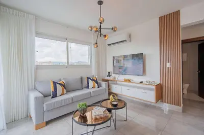 a living room with a couch and a table at Soha suites I in Santiago de los Caballeros