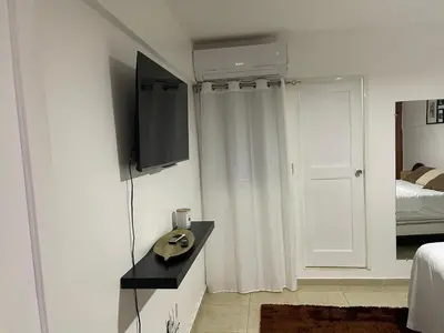 a white room with a television and a bed at Hospedaje de marant 1 in San Felipe de Puerto Plata