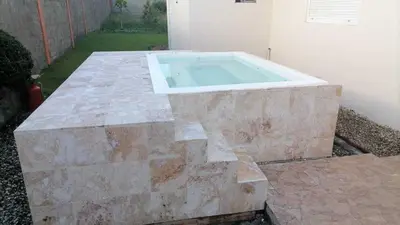 a large stone pool sitting next to a building at Beautiful Villa in Boca Chica in Boca Chica