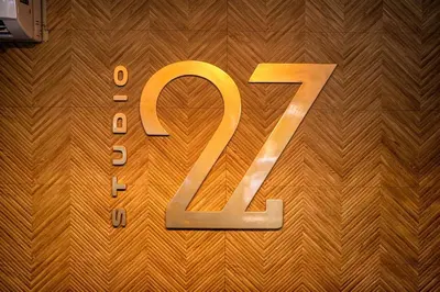 a large gold sign on a wooden wall at Studio 27 in Santo Domingo