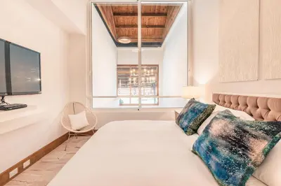 a bedroom with a bed and a tv and a window at Golf View Apt at Casa De Campo in El Infiernito