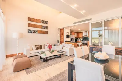 a living room with white furniture and a table at Golf View Apt at Casa De Campo in El Infiernito