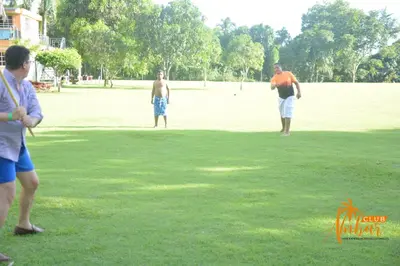 three men standing in a field playing with a frisbee at Villas Club Ámbar in Cacique