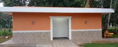 a small building with a white door and an orange wall at Villas Club Ámbar in Cacique