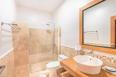a bathroom with a sink and a toilet and a mirror at 3BR Beachfront townhouse at Puerto Bahia in Santa Bárbara de Samaná