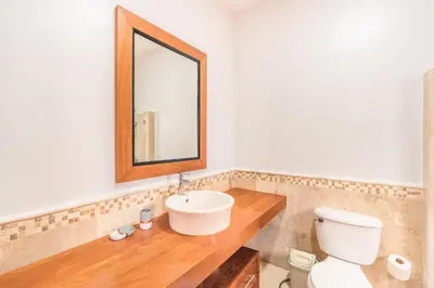 a bathroom with a sink and a toilet and a mirror at 3BR Beachfront townhouse at Puerto Bahia in Santa Bárbara de Samaná