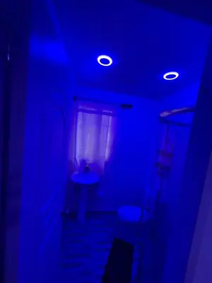a dark room with blue lights and a window at Mar azul puerto plata in San Felipe de Puerto Plata