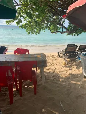 a table and chairs on a sandy beach at Mar azul puerto plata in San Felipe de Puerto Plata