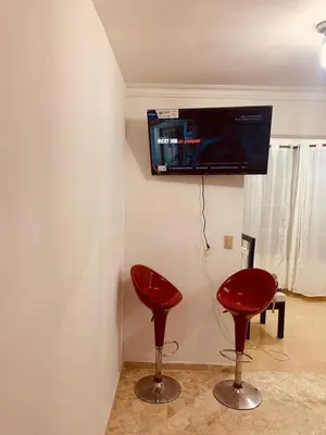 two red stools in a room with a tv on the wall at Mar azul puerto plata in San Felipe de Puerto Plata