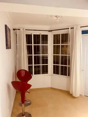 a room with a red chair and large windows at Mar azul puerto plata in San Felipe de Puerto Plata