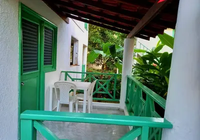 a porch with a green door and a table and chairs at Residence Nord Est in Las Terrenas