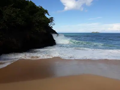 a wave crashing on a beach next to the ocean at Casa De Matias in Las Terrenas