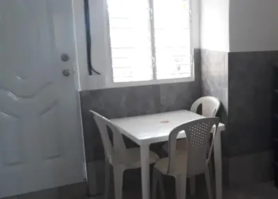 a white table and chairs in a room with a window at Casa De Matias in Las Terrenas