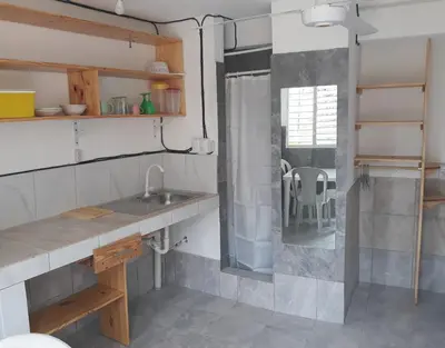 a kitchen with a sink and a chair in a room at Casa De Matias in Las Terrenas