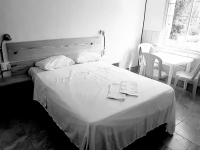 a black and white photo of a bed in a room at Casa De Matias in Las Terrenas