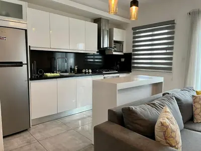 a living room with a couch and a kitchen at SOHA SUITES II in Santiago de los Caballeros