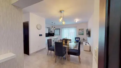 a dining room and kitchen with a table and chairs at SOHA SUITES II in Santiago de los Caballeros