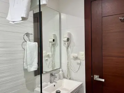a bathroom with a sink and a phone on the wall at SOHA SUITES II in Santiago de los Caballeros