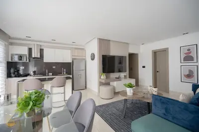 a kitchen and living room with a table and chairs at SOHA PANORAMA in Santiago de los Caballeros