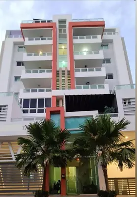 a tall building with palm trees in front of it at Torre Harriannet XIII in Santo Domingo
