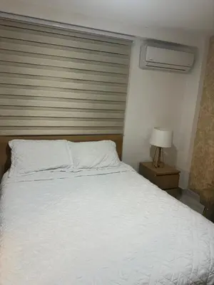a bedroom with a white bed and a window at Torre Harriannet XIII in Santo Domingo