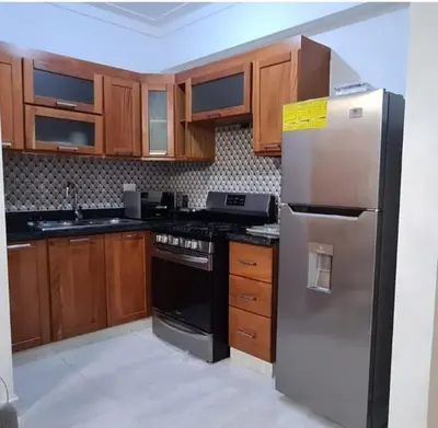 a kitchen with wooden cabinets and a stainless steel refrigerator at Torre Harriannet XIII in Santo Domingo