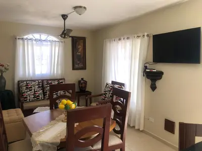 a living room with a table and chairs and a dining room at Apartamentos Kika in San Felipe de Puerto Plata