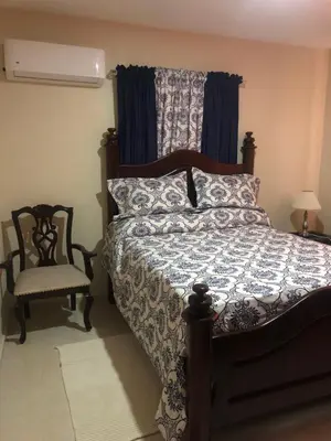 a bedroom with a bed and a chair at Apartamentos Kika in San Felipe de Puerto Plata