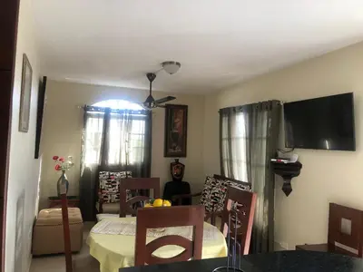 a living room with a table and a tv at Apartamentos Kika in San Felipe de Puerto Plata