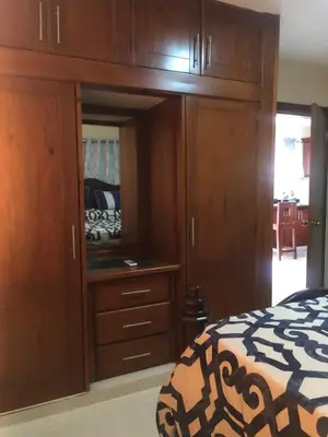 a bedroom with wooden cabinets and a bed at Apartamentos Kika in San Felipe de Puerto Plata
