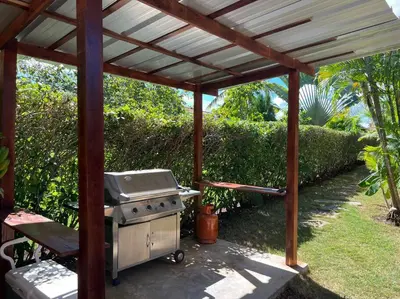 a grill under a wooden pergola in a backyard at Charming 3 bedroom villa 66 with private pool in Sosúa