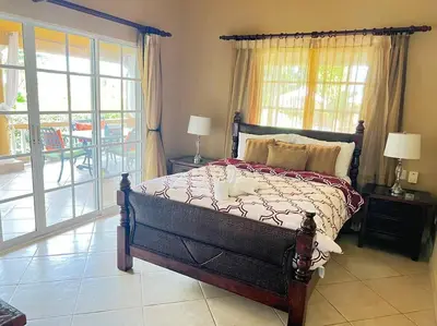 a bedroom with a large bed and a balcony at Charming 3 bedroom villa 66 with private pool in Sosúa