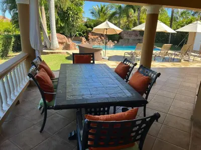 a patio with a table and chairs and a pool at Charming 3 bedroom villa 66 with private pool in Sosúa