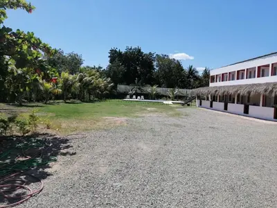 a large yard next to a building at Piscalonga Hotel Restaurant Cozy Family Operated in San Lorenzo de Guayubín