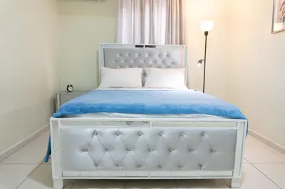 a bedroom with a white bed with a blue blanket at Gaviota Paradise in La Romana